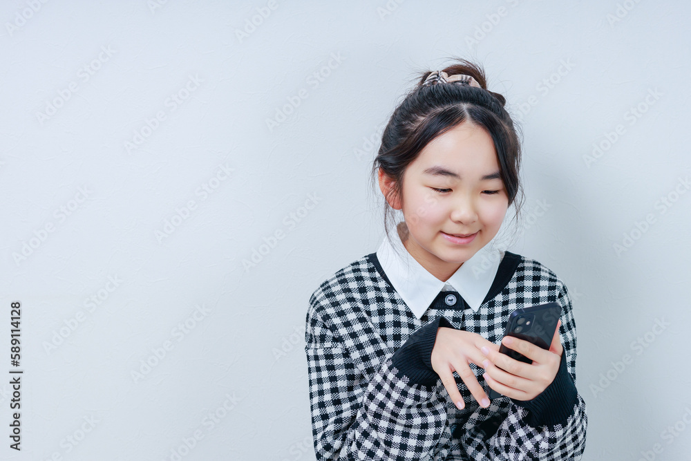 笑顔でスマホを操作する女の子 笑顔でスマホを操作する女の子