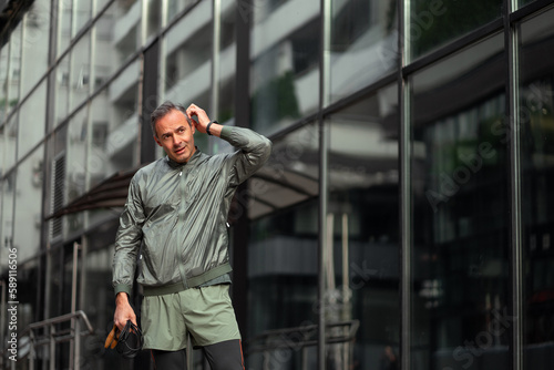 Wallpaper Mural A middle-aged man is catching his breath after skipping a jumping rope outside in an urban area. Torontodigital.ca
