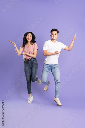 full body image of asian couple posing on purple background