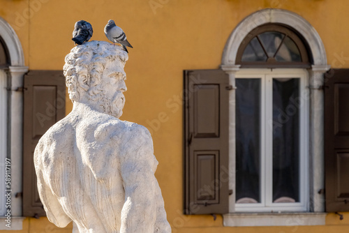 Hercules statue with two pigeons perched on the head of the greatest divine hero in Greek mythology. Udine city, Friuli Venezia Giulia, Italy. photo