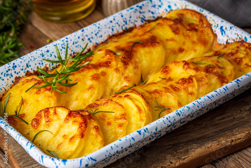 Potato gratin - graten (baked potatoes with cream and cheese) with rosemary and forks (Turkish name; Kremali patates) photo