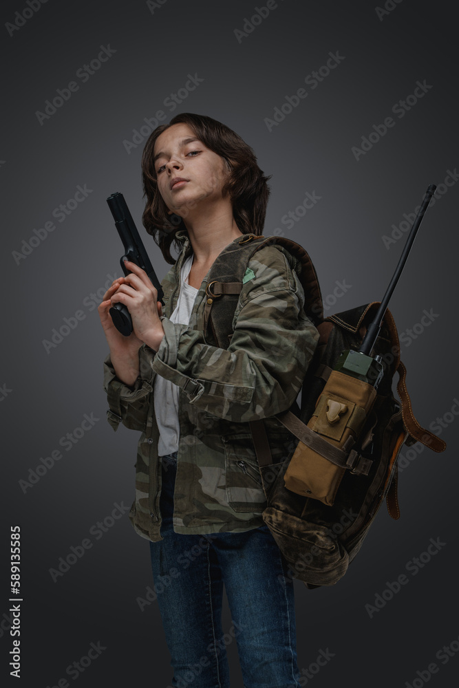 Studio shot of young girl in setting of post apocalypse with backpack and handgun. Studio shot of young girl in setting of post apocalypse with backpack and handgun.