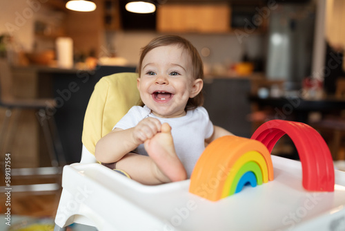 Adorable child sitting in high chair having fun