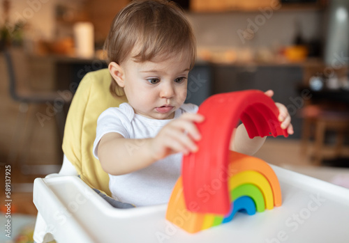 Adorable child sitting in high chair having fun