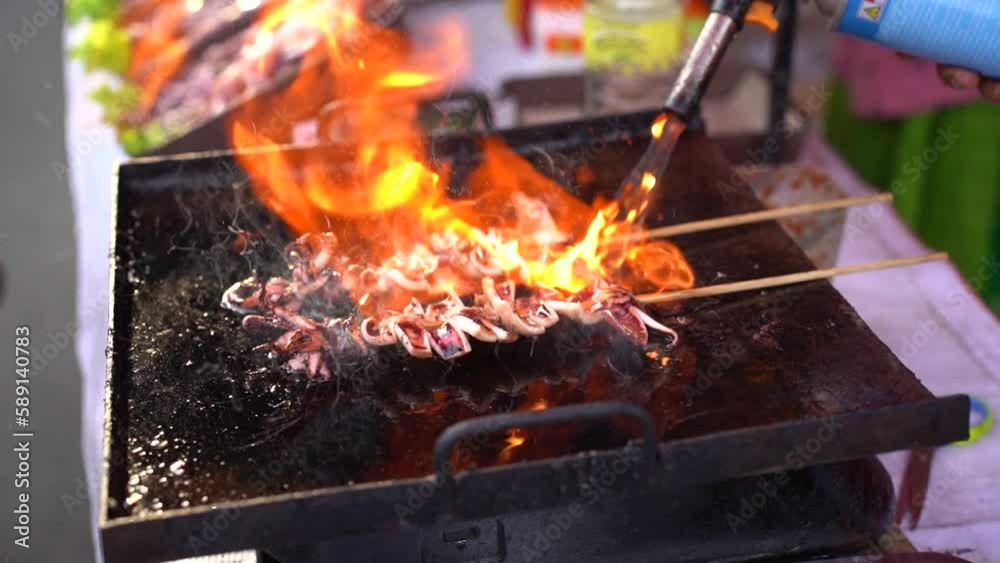 Sate squid when the process is burned. Grilled squid on skewers, Good street food in night market or ramadhan market. Sate squid when the process is burned. Grilled squid on skewers, Good street food in night market or ramadhan market.