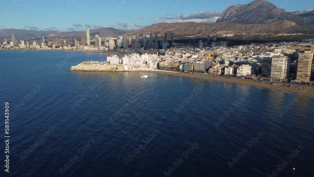 Flying backwards from the old city centre of Benidorm, and revealing the Levante beach and Puigcampana mountain in the background.