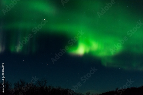 imagen paisaje nocturno con monta  as al fondo y una aurora boreal en el cielo estrellado de Islandia 