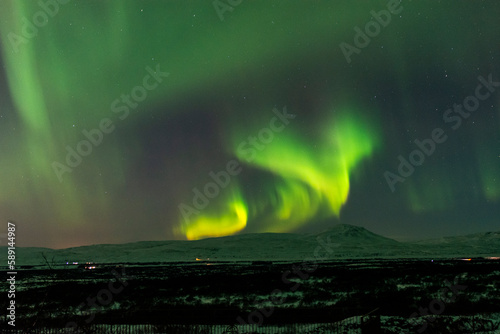 imagen nocturna de un paisaje nevado con una aurora boreal en el cielo nocturno de Islandia 