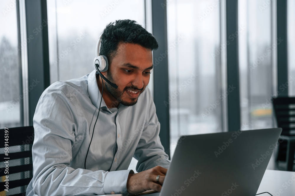 Beautiful indian man is working in the office by laptop Beautiful indian man is working in the office by laptop
