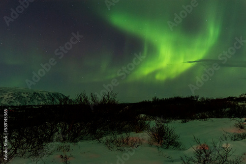 imagen paisaje nocturno con monta  as al fondo y una aurora boreal en el cielo estrellado de Islandia 