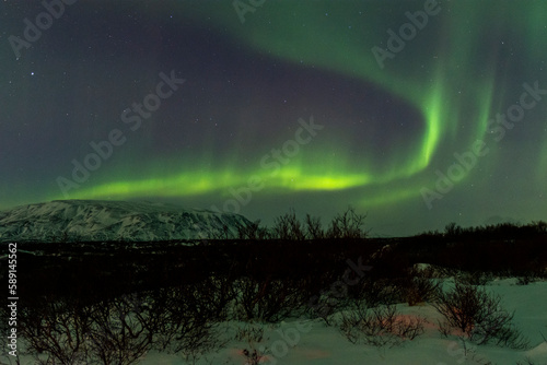 imagen de un paisaje nocturno nevado con una aurora boreal en el cielo de Islandia © carles