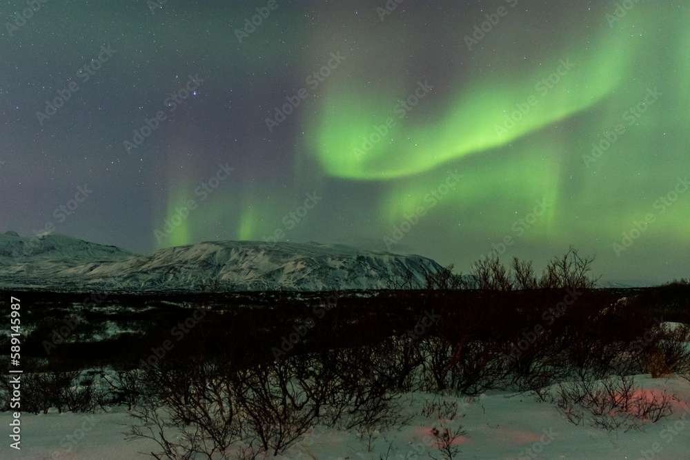 imagen de un paisaje nocturno nevado con una aurora boreal en el cielo de Islandia