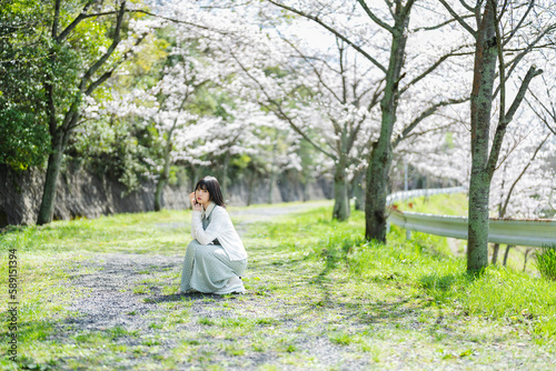 桜の花を見るショートヘアの女性