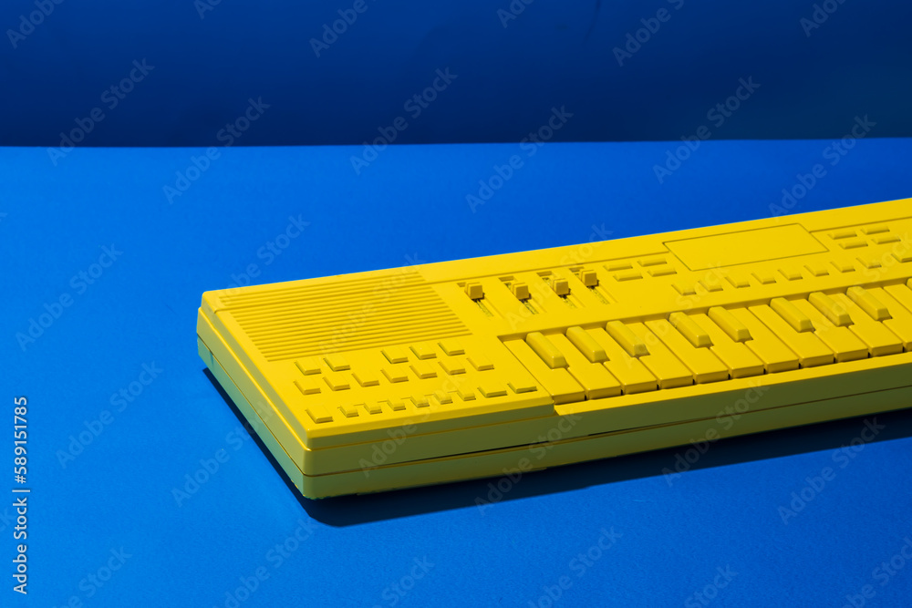 Yellow synthesizer keyboard on blue background Yellow synthesizer keyboard on blue background