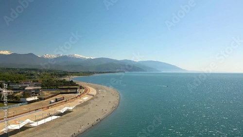 4k Aerial view of Adler, Sochi Beach, Town and Mountains. Waterfront Stretches Across the Coastline. Panoramic view of sea, mountains and city. 4k Aerial view of Adler, Sochi Beach, Town and Mountains