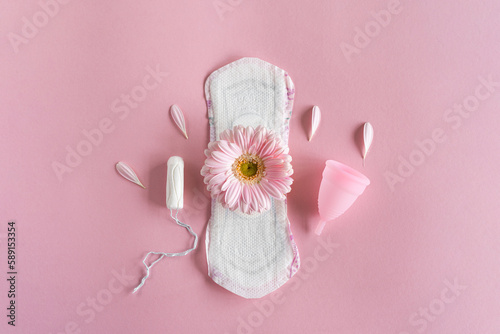 Menstruation period concept. Hygienic white female pad, Menstrual cup and tampon with pink flowers. Menstruation, protection. Women's health photo