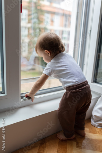 One year old child looking trough the window