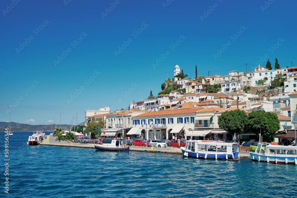 Fototapeta premium Scenic view of Poros island in a typical summer day. Old town with traditional white houses near the sea. Saronic gulf, Greece, Europe.