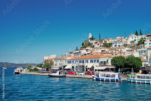 Scenic view of Poros island in a typical summer day. Old town with traditional white houses near the sea. Saronic gulf, Greece, Europe. © luengo_ua