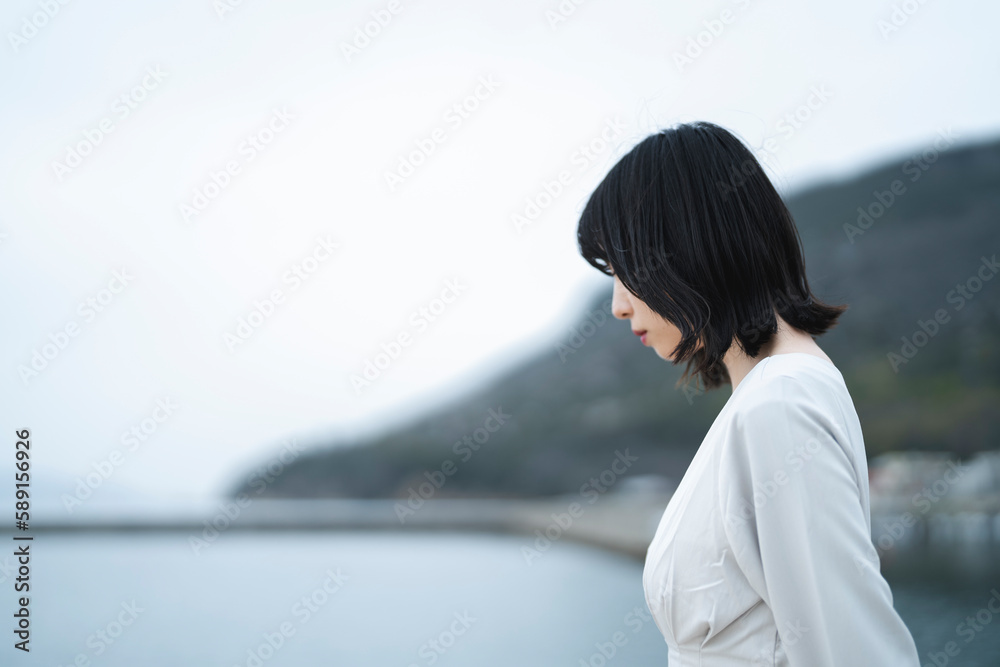 夕暮れの海にいる女性