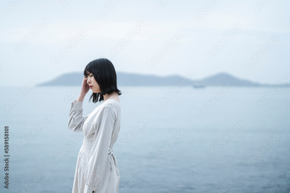 夕暮れの海にいる女性