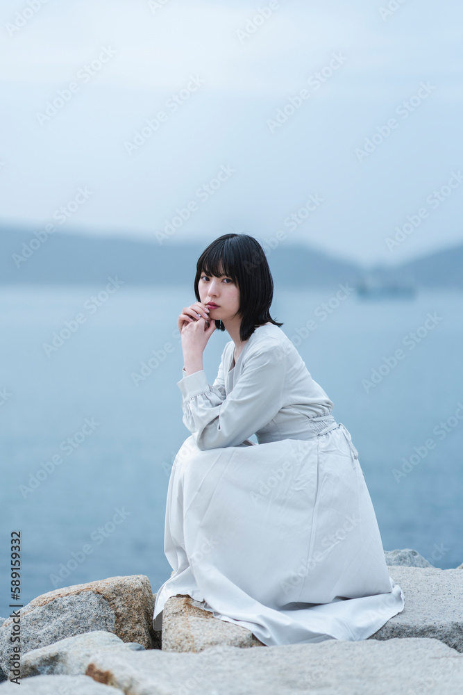 夕暮れの海にいる女性