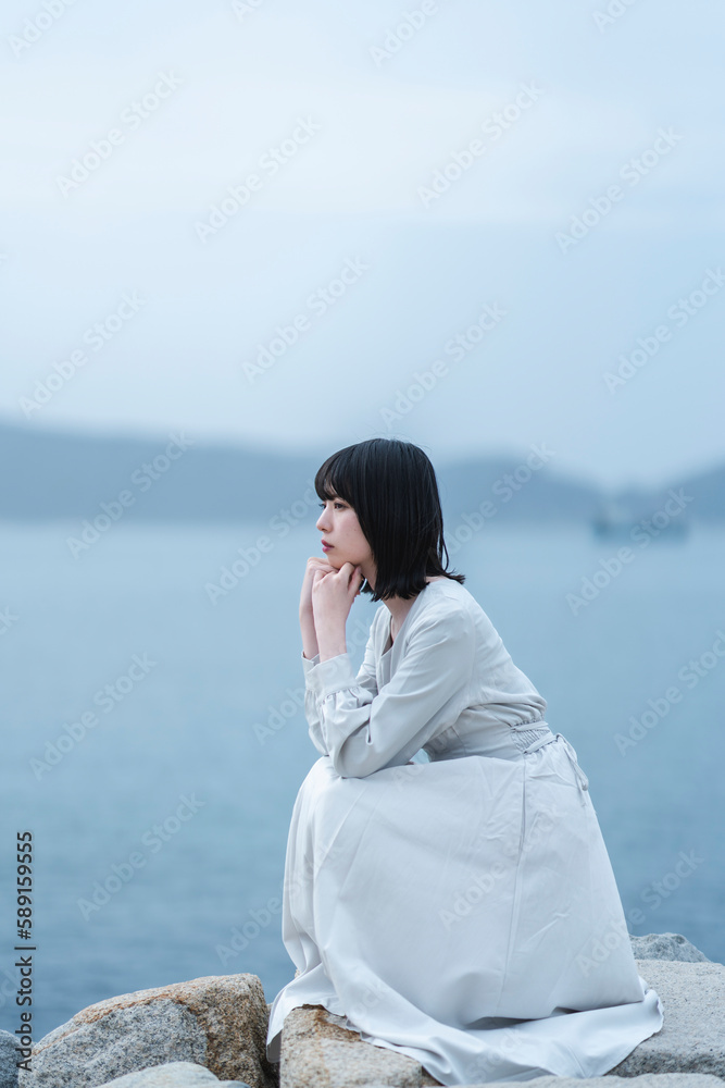 夕暮れの海にいる女性