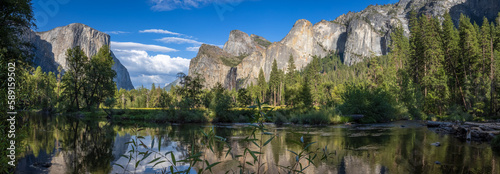 Fototapeta Naklejka Na Ścianę i Meble -  Panorama of the Yosemite Valley, including El Capitan, Cathedral Rocks and Bridalveil Falls, reflected at the Merced River in summer sunset.