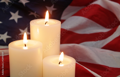 Burning candles on United States flag background. 