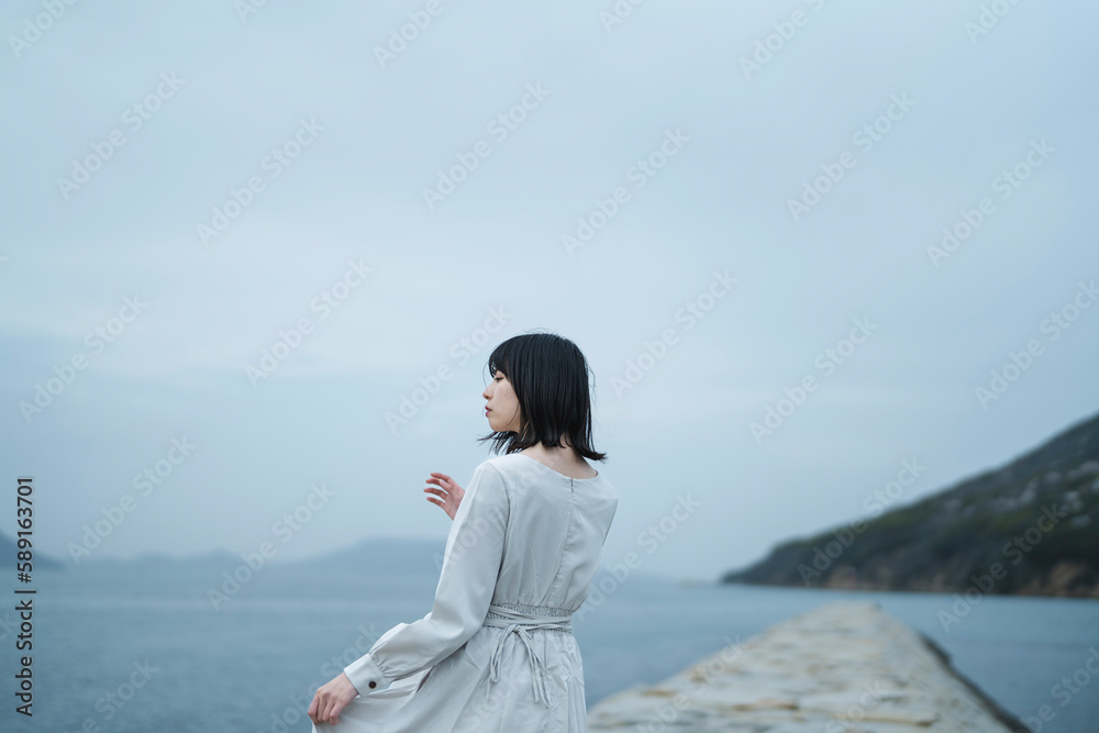 夕暮れの海にいる女性