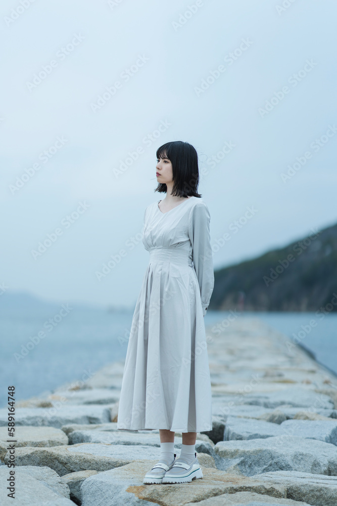 夕暮れの海にいる女性