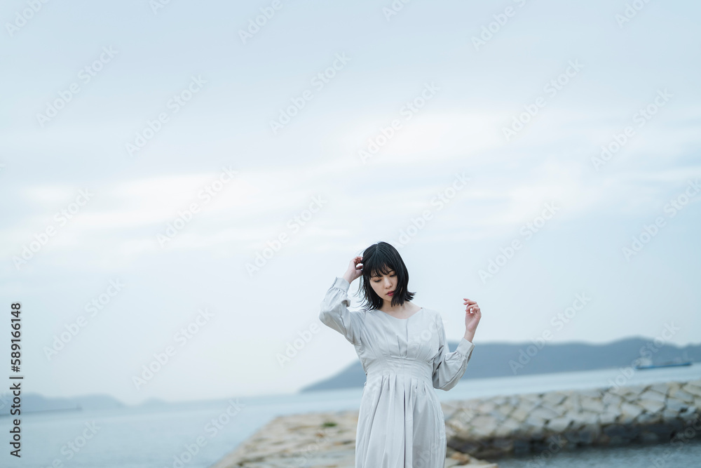 夕暮れの海にいる女性