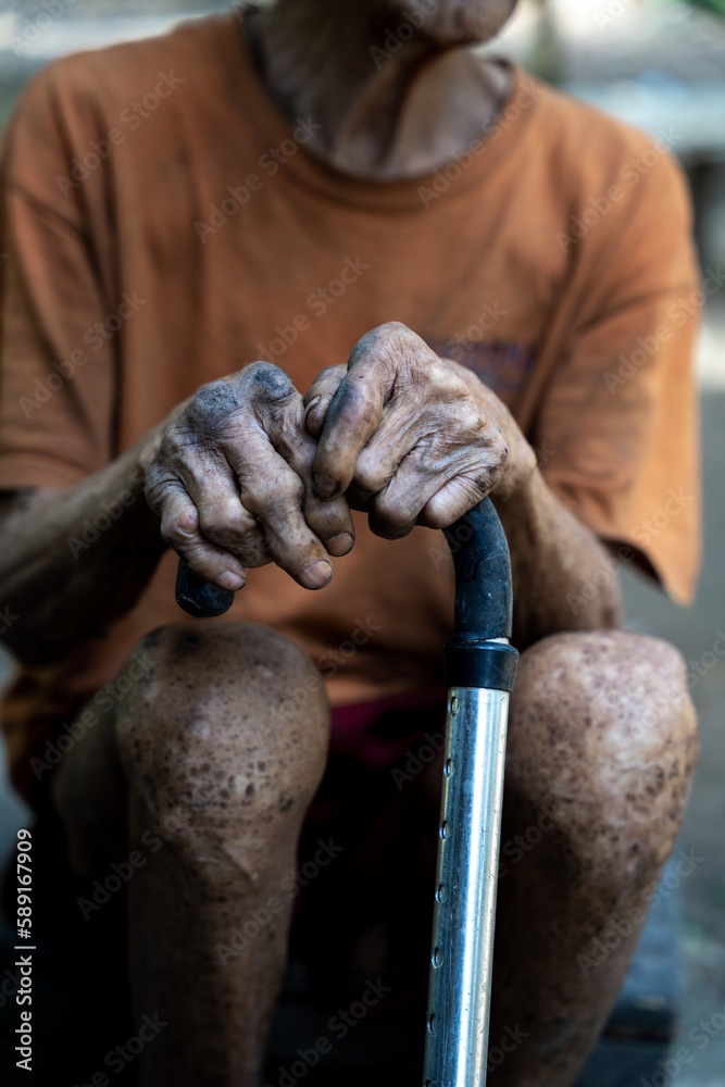 Old man's hand wearing a cane at home
