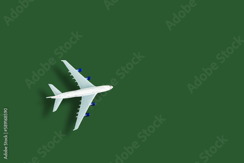 Airplane model. White plane on green background. Travel vacation concept. Summer background. Flat lay, top view, copy space. © Angelov