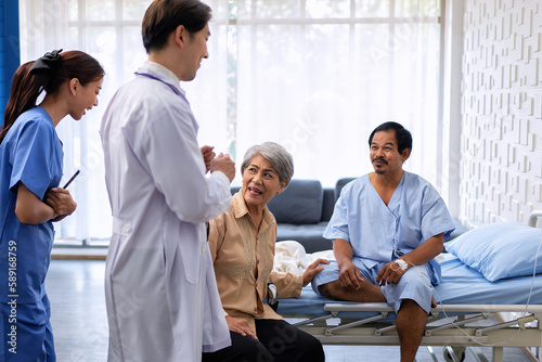 Принти на полотні At treatment room patient sitting on bed nurse and doctor congrats him for disch