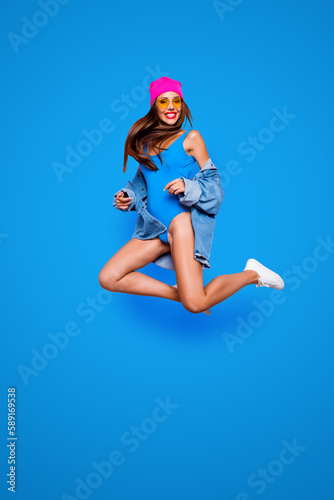 Vertical full size length body studio photo portrait of cheerful attractive pretty rejoicing confident funny fancy girl jumping up isolated bright color vivid shinny background