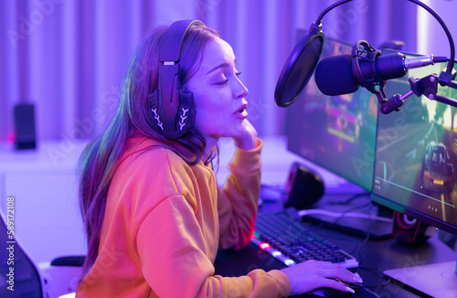 A determined online streamer creates a stream and grows an audience that can generate income through subscriptions and advertising. A contemporary, colorful, and artificially lights home office.