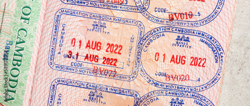 Entry and exit stamps placed in a passport by Cambodia border control officials as part of their immigration control and customs procedures. Many rubber stamps for a travel document of a tourist  photo