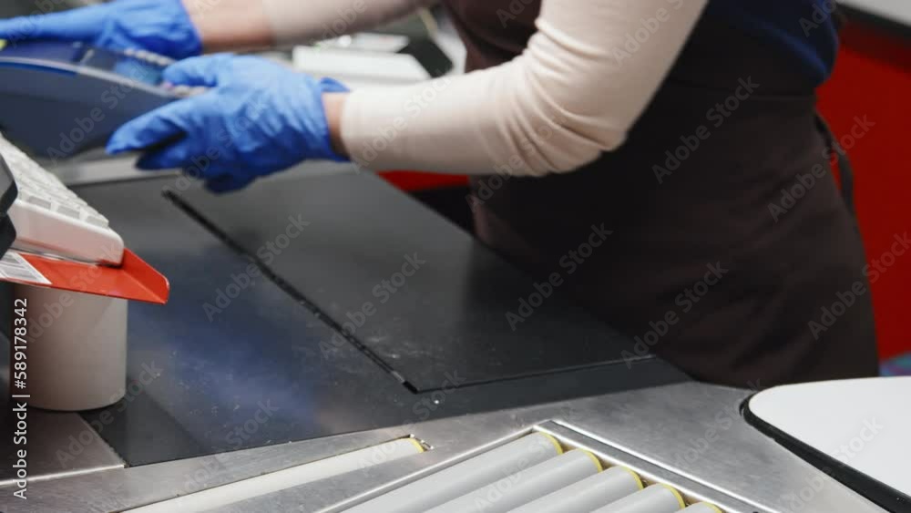 Close-up shot of cashier in protective gloves giving credit card reader to customer and she paying for goods with credit card Close-up shot of cashier in protective gloves giving credit card reader to customer and she paying for goods with credit card