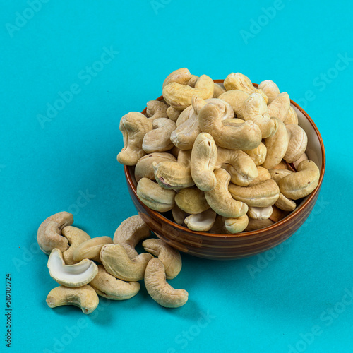 Cashew nuts in a bowl on blue background