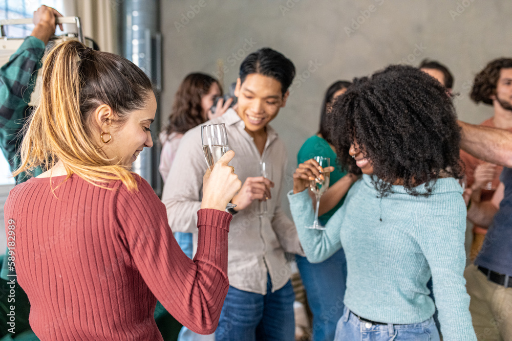 Large group of people organize a party with music and dance in a private house, multiracial friends dancing together