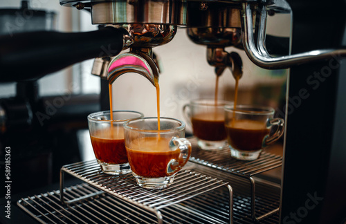 Professional espresso machine while preparing two espressos shot in a coffee shop. Close-up of espresso pouring from the coffee machine