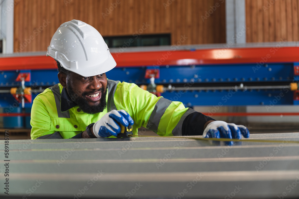 Portrait African American engineer man checking metal with tape measure at metal sheet factory Portrait African American engineer man checking metal with tape measure at metal sheet factory