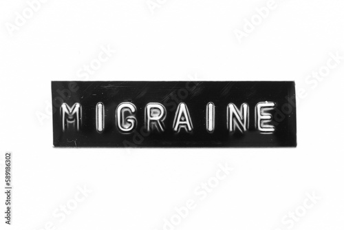 Black color banner that have embossed letter with word migraine on white paper background photo