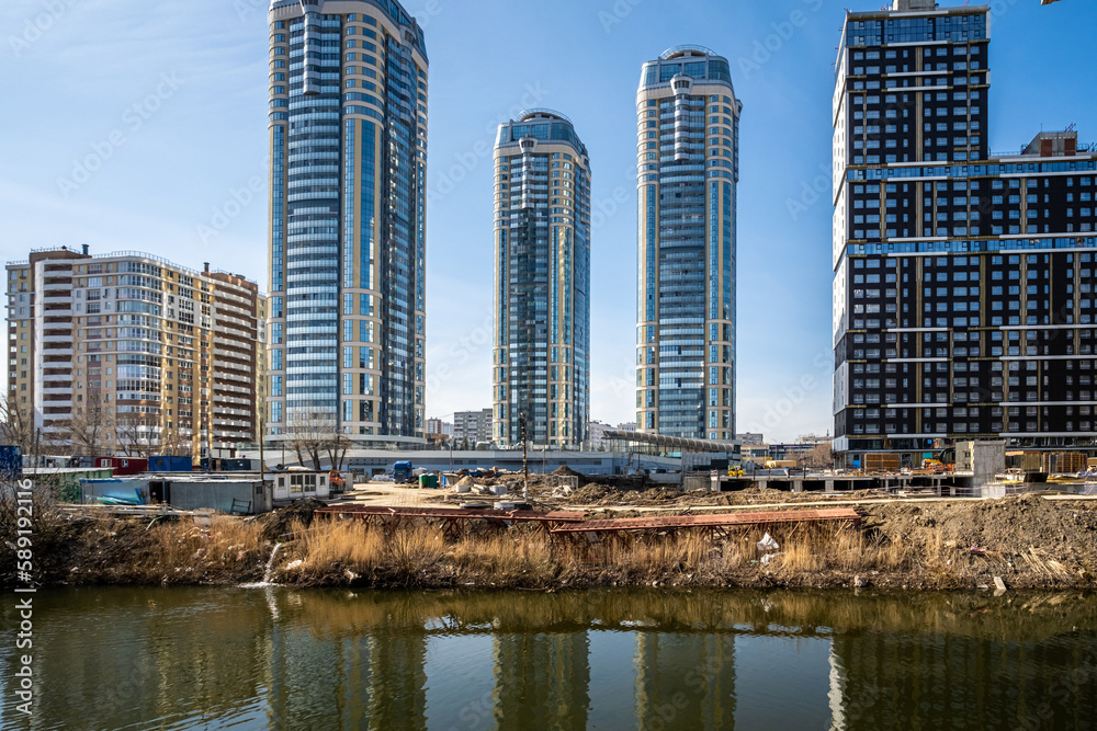 Obraz premium Construction of new high-rise buildings on the river bank.