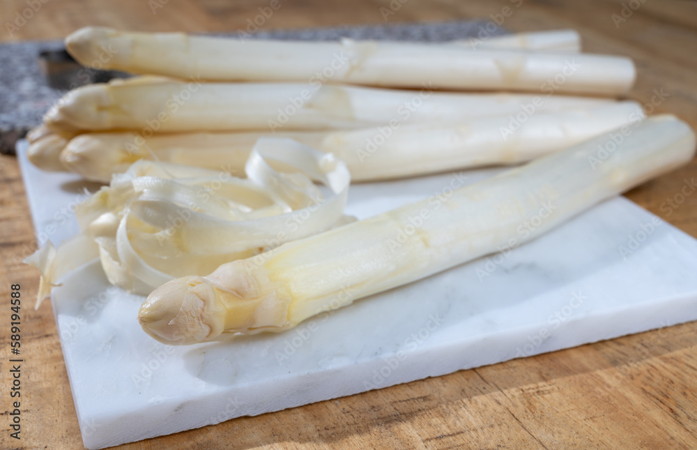 How to peel asparagus, spring season, new harvest of Dutch, German white asparagus, bunch of raw white asparagus How to peel asparagus, spring season, new harvest of Dutch, German white asparagus, bunch of raw white asparagus