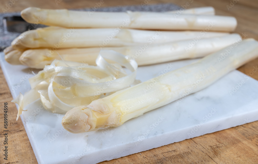 How to peel asparagus, spring season, new harvest of Dutch, German white asparagus, bunch of raw white asparagus How to peel asparagus, spring season, new harvest of Dutch, German white asparagus, bunch of raw white asparagus
