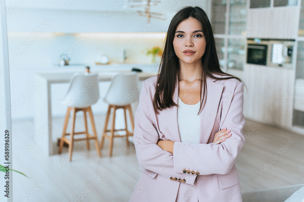 Confident Asian businesswoman in suit standing at home looks at camera against blurry kitchen, Calm Korean entrepreneur ready for new working week. Business people, success. Ceo thinks about work. Confident Asian businesswoman in suit standing at home looks at camera against blurry kitchen, Calm Korean entrepreneur ready for new working week. Business people, success. Ceo thinks about work.