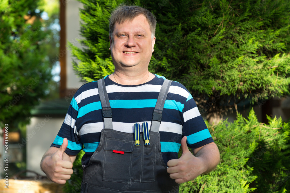 Naklejka premium Portrait of a happy positive working man in overalls.