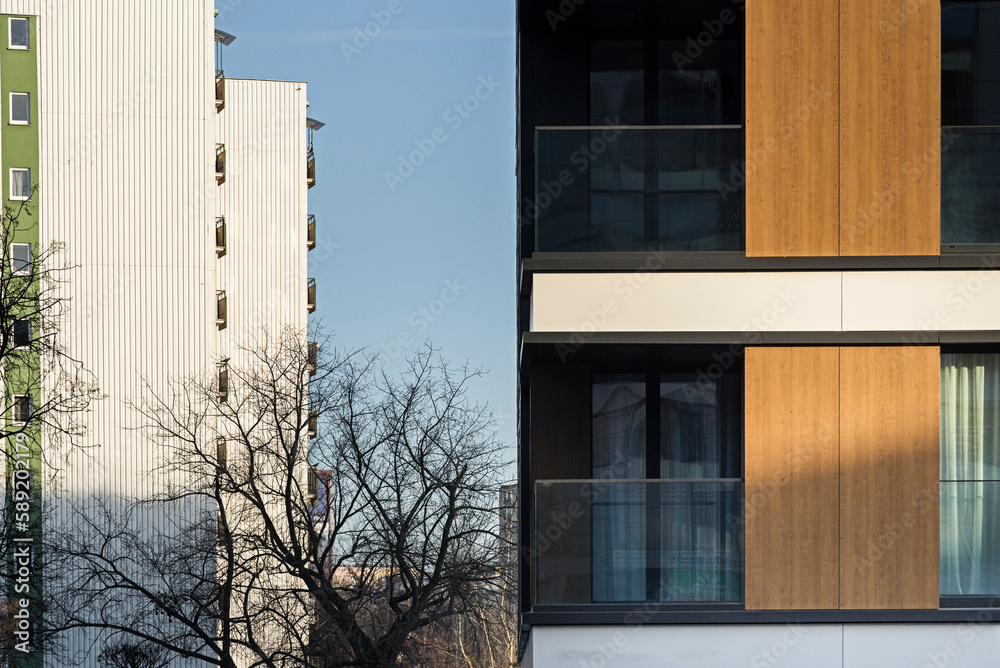 Detal na nowoczesny budynek wielorodzinny w centrum miasta. Duża ilość kondygnacji. Balkony i loggie. Słoneczna pogoda - obrazy, fototapety, plakaty 